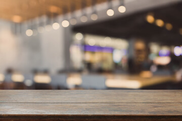 Obraz premium Wood table top and blurred bokeh cafe and coffee shop interior background with vintage filter - can used for display or montage your products.