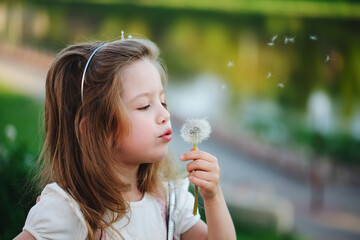 little girl with dandelion in park