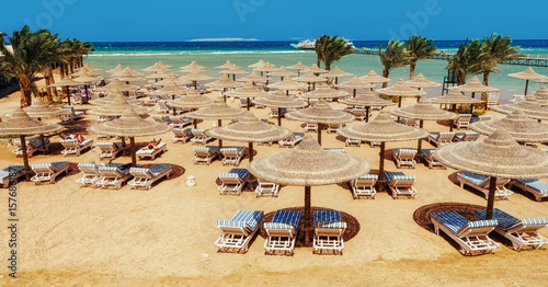 Loungers and parasols against a clear blue sea and sky