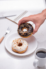 Working desk with dessert and coffee. Cake donuts with a cup of espresso on marble table top.