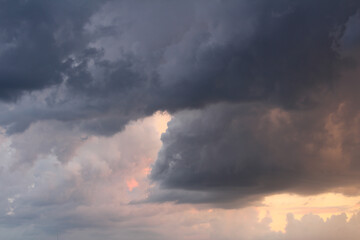 Naklejka na ściany i meble Heavy grey storm clouds texture with orange color