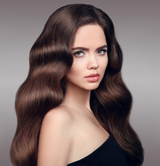 Fototapeta premium Beauty hair. Beautiful model girl with clean fresh skin and shiny brown straight wavy long hair isolated on grey background. Facial treatment. Cosmetology & Care products.