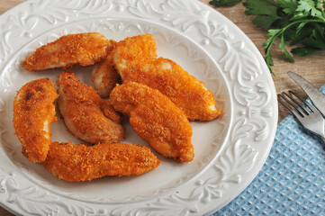 chicken nuggets in bowl on wooden background