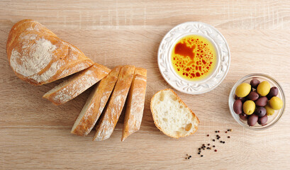 fresh bread, cut into slices with olives and olive oil with balsamic vinegar in a bowl