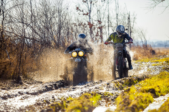 Rally motorbike rider is ahead of another on a dirt road