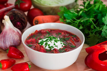 Borscht. Red soup in bowl with sour cream, isolated on wooden background. Close-up. Top view
