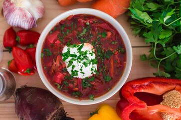 Borscht. Red soup in bowl with sour cream, isolated on wooden background. Close-up. Top view