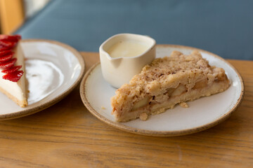Apple Crumble Pie and Strawberry Cheesecake on Wooden Table