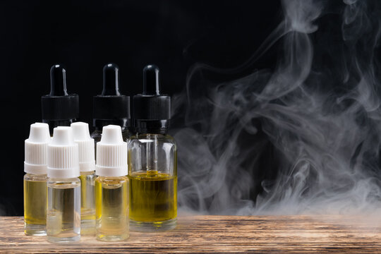 Set of smoking liquids in glass jars on a background of smoke