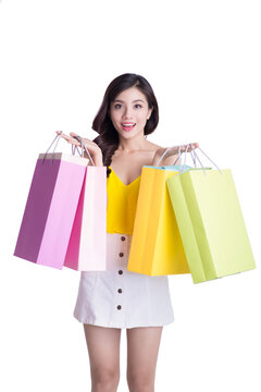 Asian smiling young woman holding colorful paper bags. Concept for shop sales. Isolated on white background