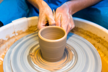 Fototapeta na wymiar Pottering - creating a clay cup in process
