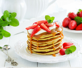 Pancakes with caramel and strawberries for breakfast.