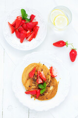 Pancakes with caramel and strawberries for breakfast.