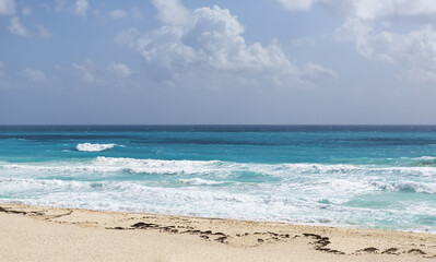 View on the beach. Shore of the Caribbean ocean. Soft sand beach with turquoise water and powerful waves. Tropical wallpaper.