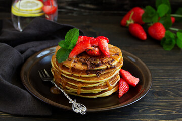 Pancakes with caramel and strawberries for breakfast.