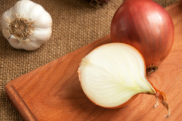  Various onions on a board on a background sacking, burlap. Copy space. Space for text.