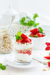 Dessert in a glass with granola, yogurt and strawberries. Useful breakfast.