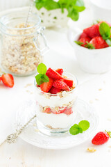 Dessert in a glass with granola, yogurt and strawberries. Useful breakfast.
