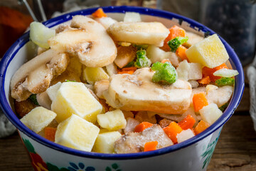 Frozen vegetables in a metal bowl.