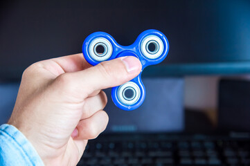 Man's hand holds a spinner on the background of a personal computer close-up