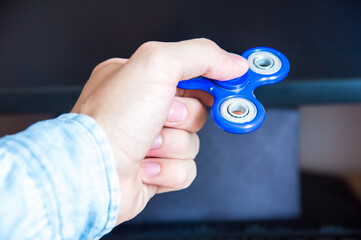 Man's hand holds a spinner on the background of a personal computer close-up