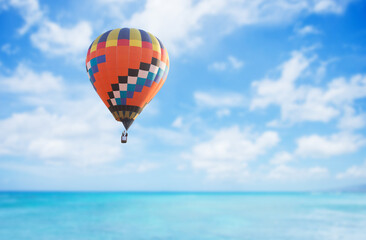 Fototapeta na wymiar Colorful hot air balloon over blue sea