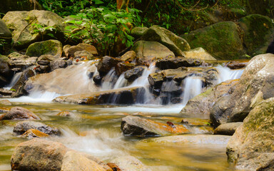 Naklejka na ściany i meble Beautiful and small waterfall in tropical forest, Thailand, long expose shutter