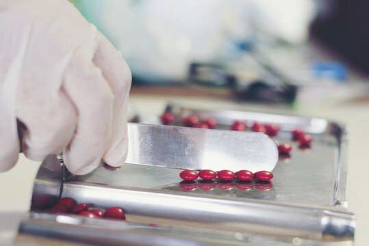 Counting tablets medical pills on stainless steel tray.Health care and medical concept