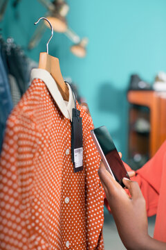 Woman taking mobile phone photo of blouse's label
