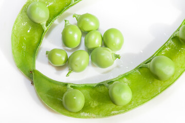 Green peas, close-up on a white background, plate