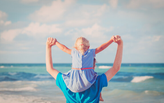 father and daughter on shoulders play at sky