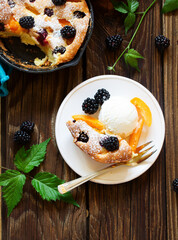 Summer cake Clafoutis with blackberries and apricots. .