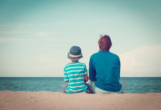 Father And Little Son Talking On Beach