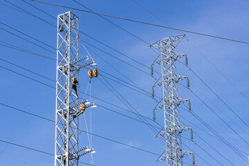 electricity transmission pylon with electricity engineer worker and blue sky background.