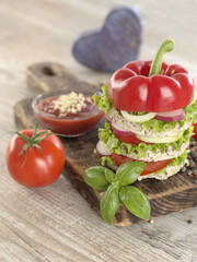 Vegetarian sandwich with vegetables on a wooden board. 