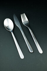 Stainless steel cutlery on a dark background