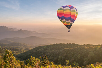 Kleurrijke heteluchtballon over de berg bij zonsondergang