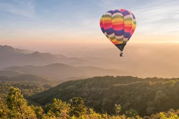 Fotobehang Ballon Kleurrijke heteluchtballon over de berg bij zonsondergang