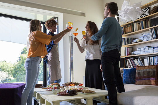 Friends having appetizers clinking glasses