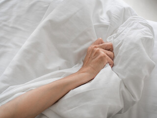 hand of women pulling white sheets in lust and orgasm.