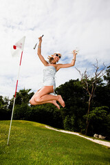 femme sexy qui saute de joie sur un parcours de golf