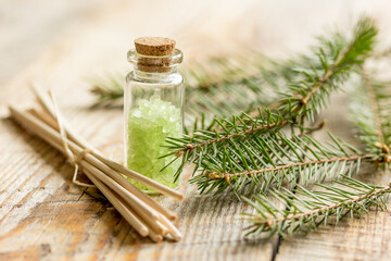 fir branches and spruce bath salt on wooden table background