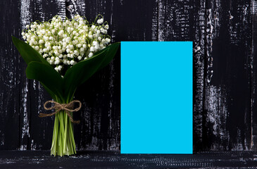 Lily of the valley on dark wooden background. Lily of the valley bouquet. Space for text.