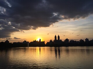 Fototapeta na wymiar Jacqueline Kennedy Onassis Reservoir lake and buildings in Manhattan with sunset