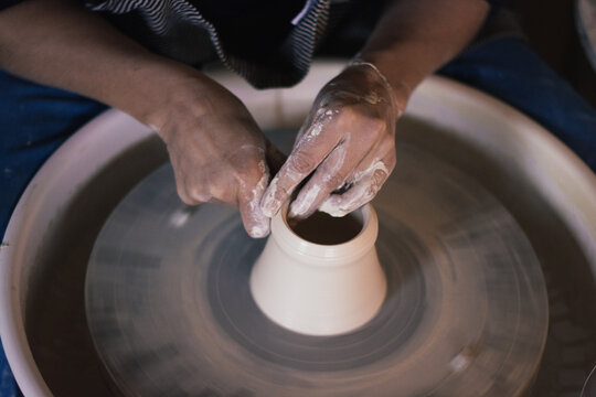 mains de c&eacute;ramiste sur le tourneau poterie