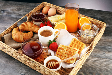 breakfast on table with waffles, croissants, coffe and juice