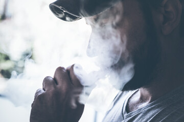 male person holding an ecig and vaping