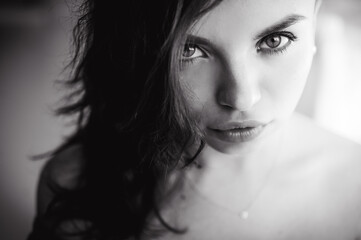 Fototapeta premium close-up portrait of a beautiful young sexy brunette girl with expressive eyes and eyes and full lips, posing for the camera