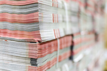 Stack of magazines in print plant ready for delivery. Packaging, delivery department, selective focus background