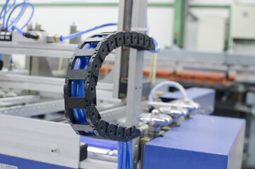 Industrial machine flexible power trak wire tray moving mechanism detail, selective focus copyspace...